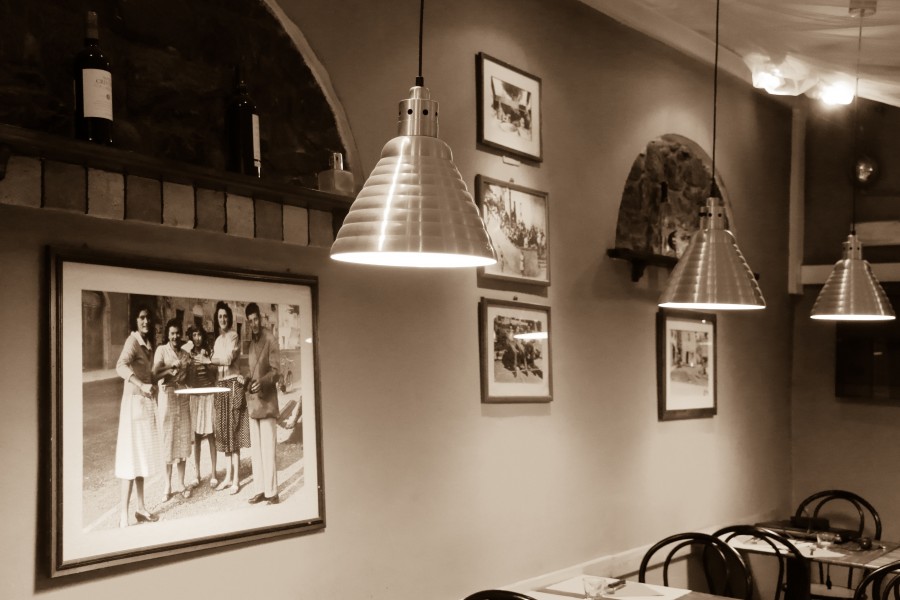 Interno del locale con lampade a sospensione e fotografie d'epoca alle pareti